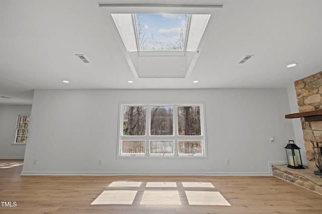 unfurnished living room with recessed lighting, visible vents, a stone fireplace, and light wood finished floors