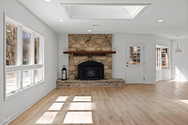 unfurnished living room with a fireplace, wood finished floors, visible vents, and a wealth of natural light