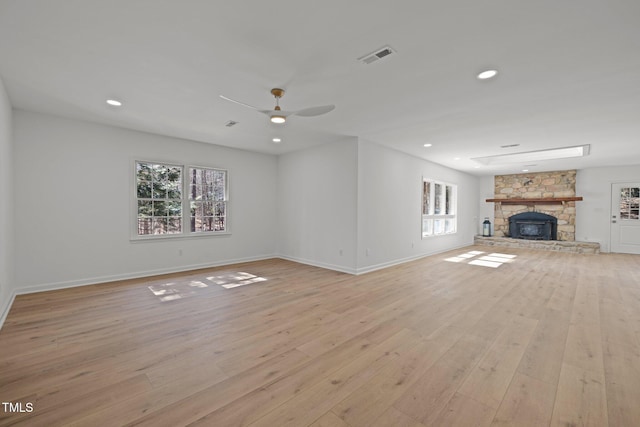 unfurnished living room featuring a ceiling fan, visible vents, light wood-style flooring, recessed lighting, and a fireplace