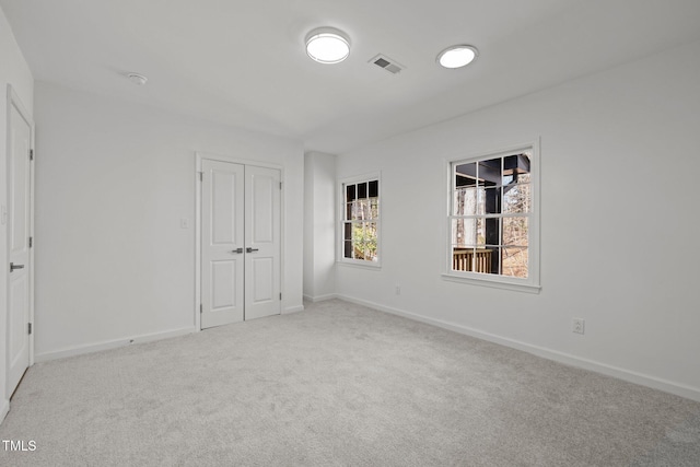 unfurnished bedroom with visible vents, baseboards, a closet, and carpet flooring