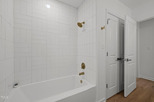 bathroom with baseboards, wood finished floors, and shower / bathtub combination