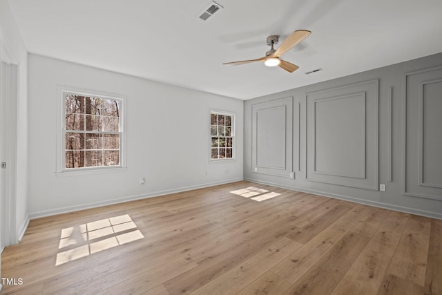 unfurnished bedroom with visible vents, light wood-style flooring, a ceiling fan, and baseboards