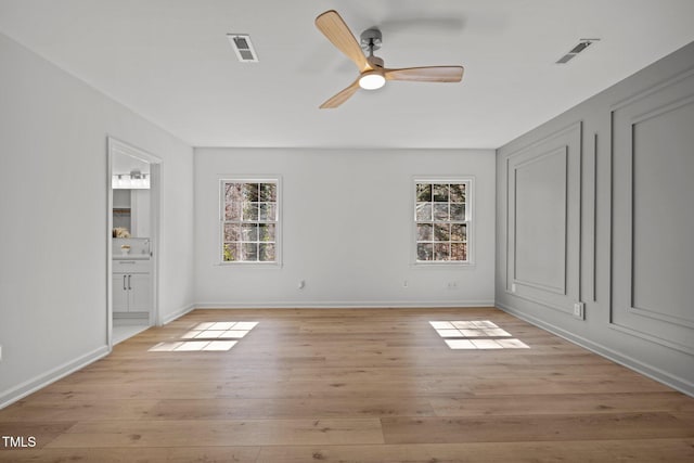 unfurnished bedroom featuring light wood-type flooring, visible vents, and multiple windows