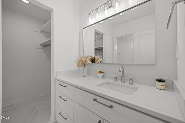 bathroom featuring marble finish floor, vanity, and baseboards