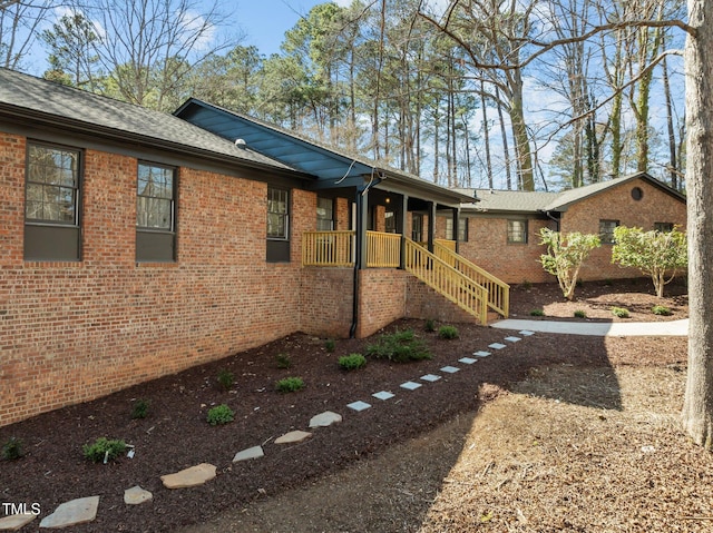 view of property exterior with brick siding and roof with shingles