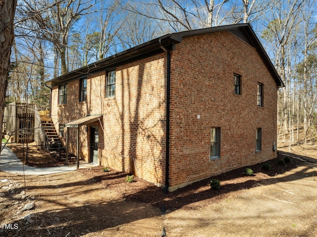 view of property exterior featuring stairs and brick siding