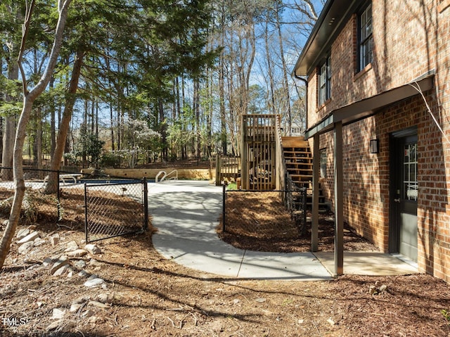 view of yard with a wooden deck, stairs, and fence