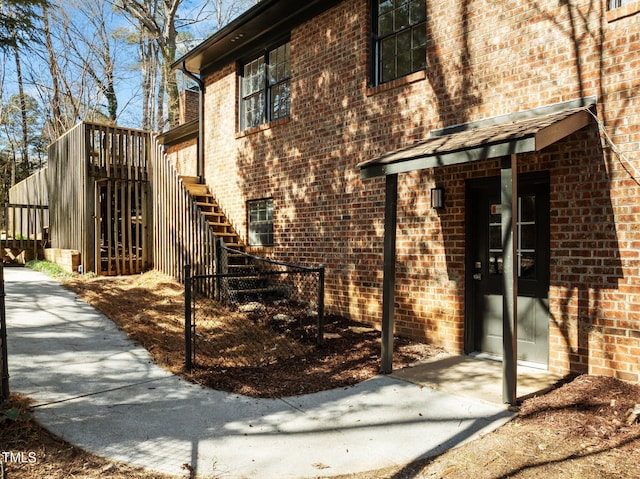 view of side of property with brick siding and stairway