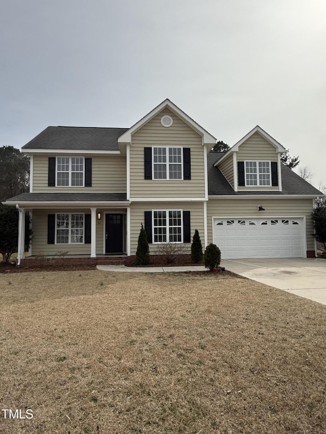 traditional-style house featuring a garage, a front lawn, driveway, and a shingled roof