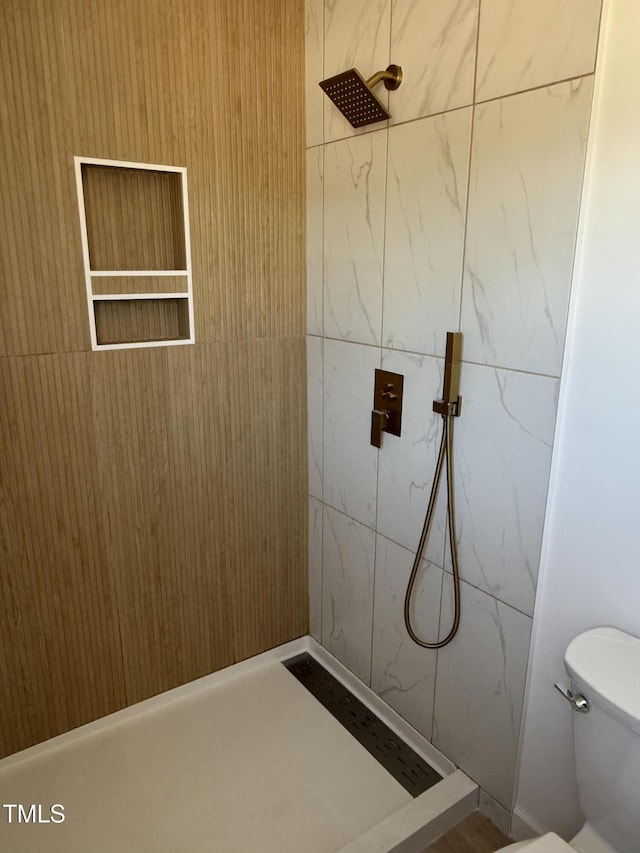 bathroom featuring toilet and tiled shower