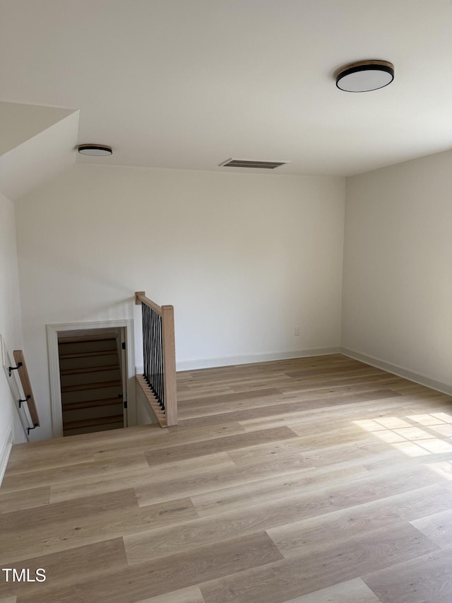 spare room featuring wood finished floors, visible vents, and baseboards