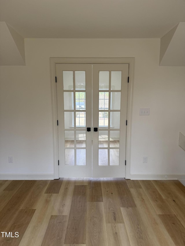 doorway featuring wood finished floors, french doors, and baseboards