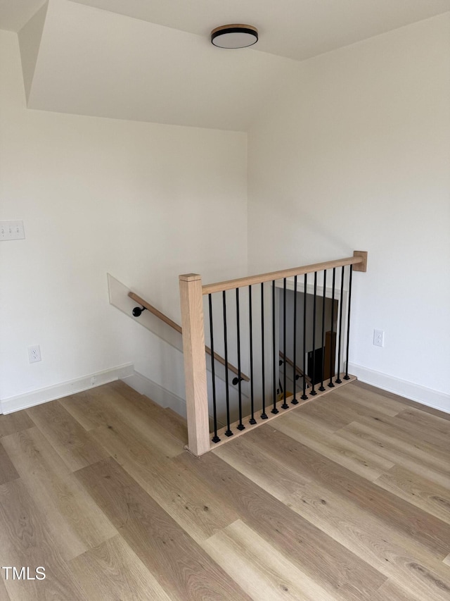 stairs with wood finished floors and baseboards