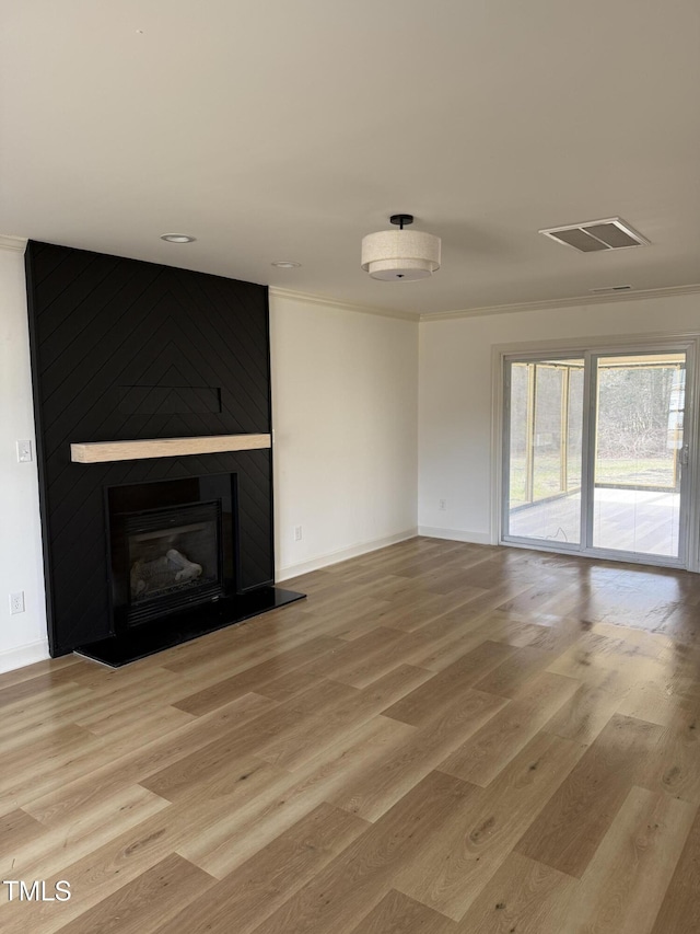 unfurnished living room with visible vents, a fireplace, baseboards, and light wood-style floors