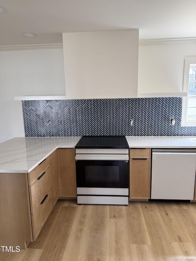 kitchen featuring light wood-style flooring, crown molding, electric stove, and white dishwasher