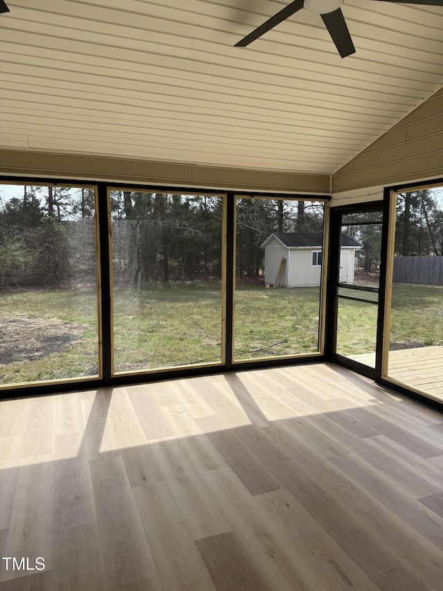 unfurnished sunroom with lofted ceiling and a ceiling fan