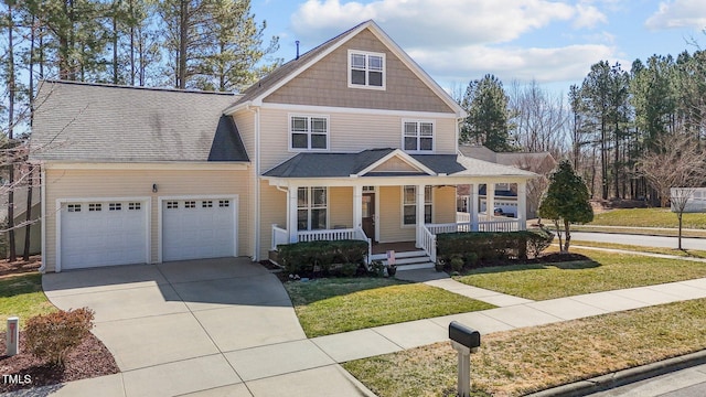 view of front of home featuring a front yard, an attached garage, covered porch, and driveway