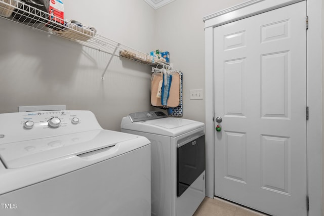 laundry room featuring laundry area, light tile patterned floors, and washer and clothes dryer