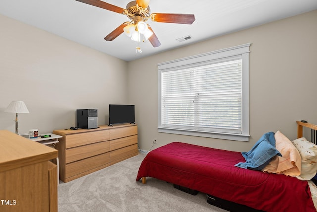 bedroom with light colored carpet, visible vents, and ceiling fan