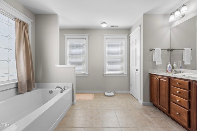 bathroom featuring visible vents, baseboards, double vanity, tile patterned flooring, and a garden tub