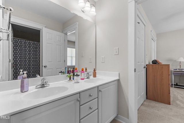 full bath with double vanity, baseboards, and a sink