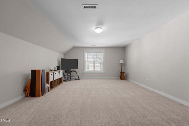 additional living space featuring baseboards and light carpet