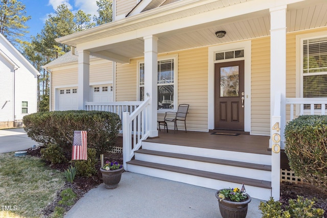 entrance to property featuring a garage and a porch