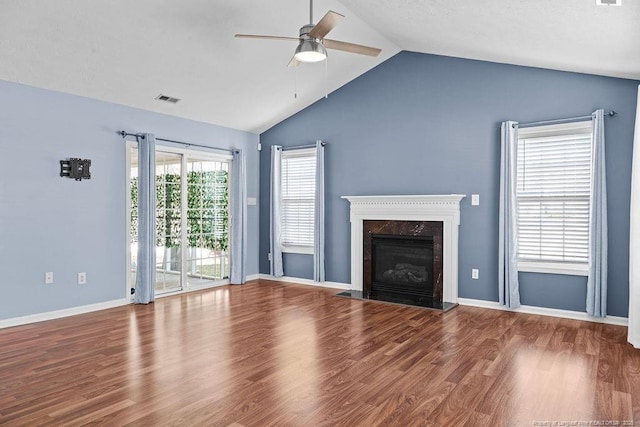 unfurnished living room with a premium fireplace, lofted ceiling, wood finished floors, and a ceiling fan