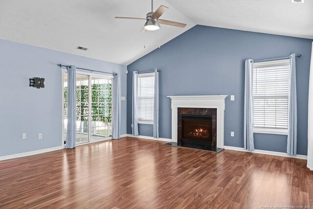 unfurnished living room featuring baseboards, lofted ceiling, a fireplace, wood finished floors, and a ceiling fan