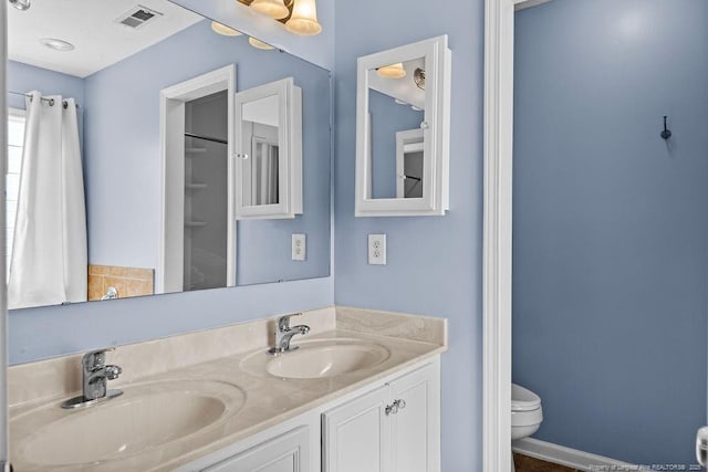 full bathroom with double vanity, visible vents, toilet, and a sink