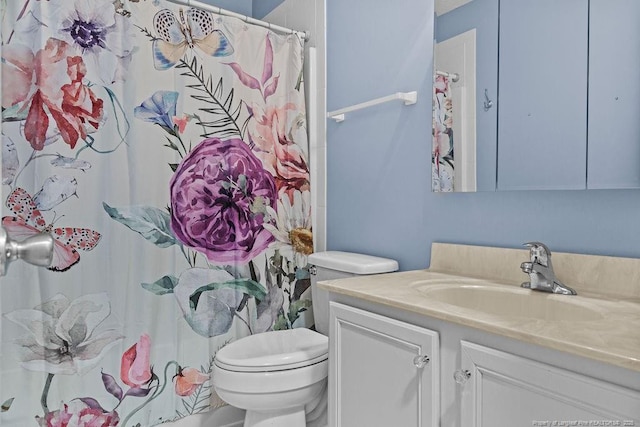 bathroom with vanity, curtained shower, and toilet