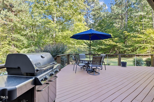 wooden deck featuring a grill and outdoor dining area