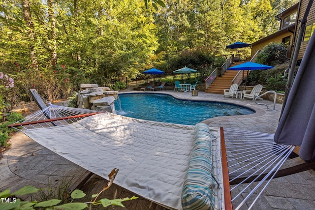 view of swimming pool with stairway, a patio area, and a fenced in pool