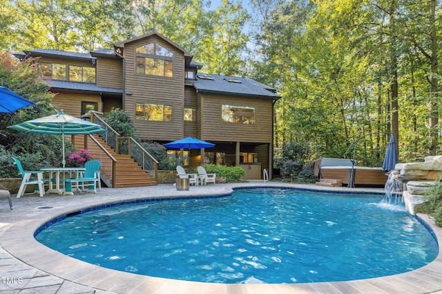 pool featuring a patio area, outdoor dining area, stairs, and a hot tub