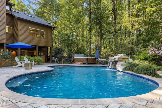 pool featuring a hot tub and a patio