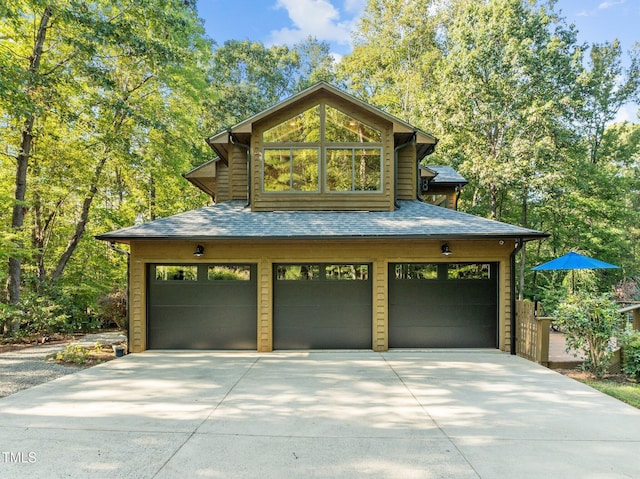 view of front of house featuring a garage, driveway, and roof with shingles