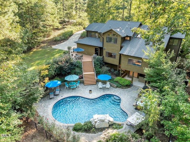 pool featuring stairway, outdoor dining area, a patio area, and a wooden deck