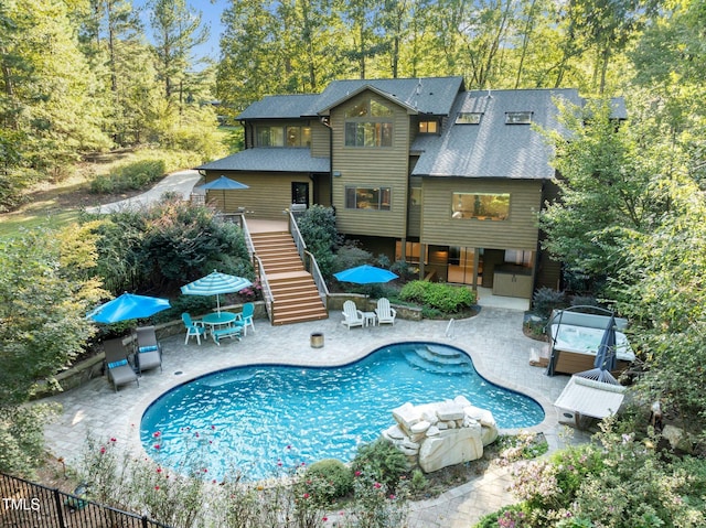 view of swimming pool featuring outdoor dining space, stairway, a fenced in pool, a jacuzzi, and a patio area