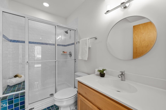 full bathroom featuring a stall shower, toilet, and vanity