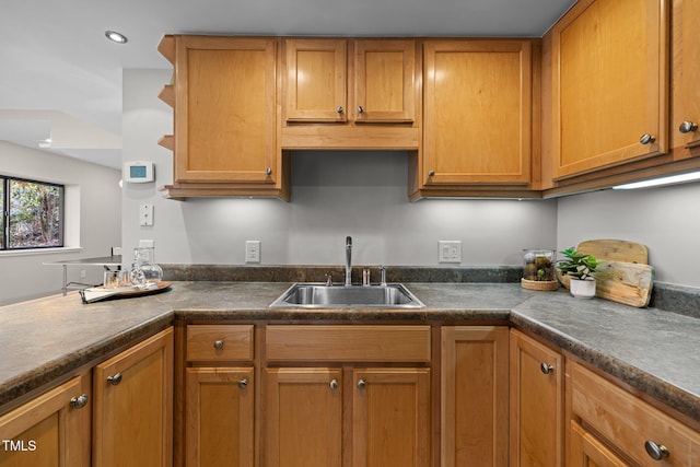 kitchen with dark countertops, brown cabinets, and a sink