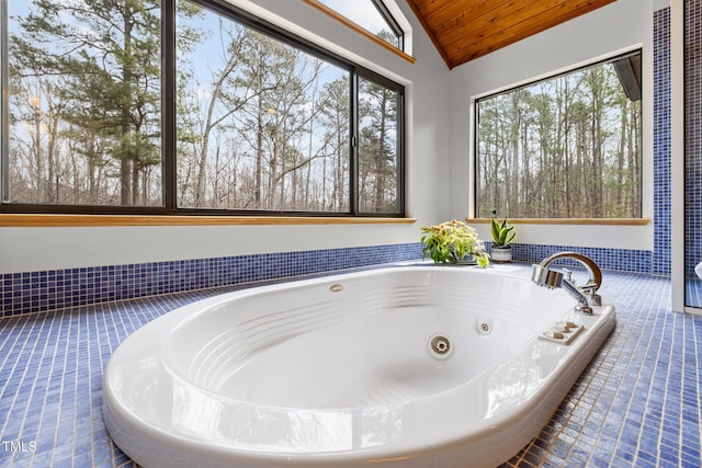 bathroom featuring a whirlpool tub, a healthy amount of sunlight, wood ceiling, and vaulted ceiling