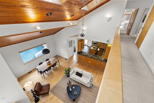 living room with wood finished floors, wood ceiling, a healthy amount of sunlight, and ceiling fan