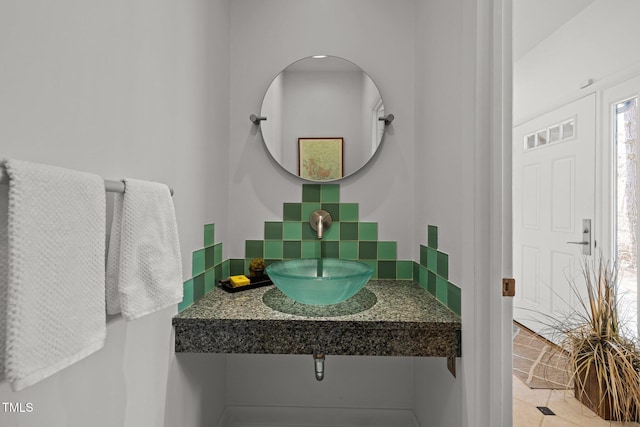 bathroom featuring decorative backsplash and a sink