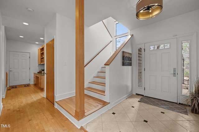 entryway with stairway, plenty of natural light, recessed lighting, and baseboards