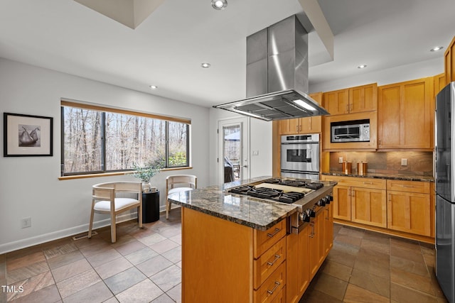 kitchen featuring a kitchen island, stainless steel appliances, dark stone counters, island range hood, and baseboards