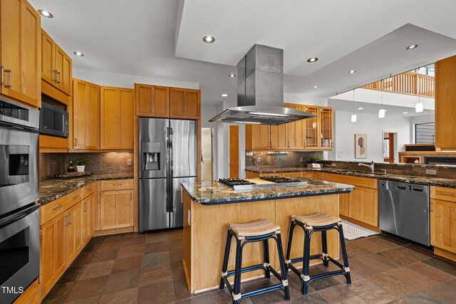 kitchen with a center island, a breakfast bar area, island range hood, stone finish floor, and stainless steel appliances