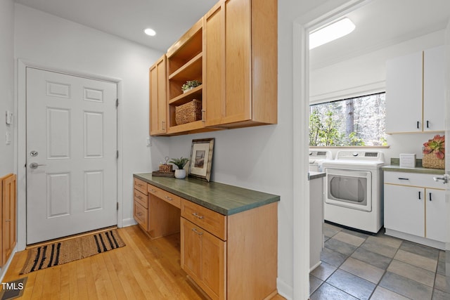 kitchen with dark countertops, open shelves, white cabinets, built in study area, and separate washer and dryer