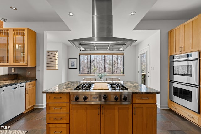 kitchen with dark stone counters, recessed lighting, island exhaust hood, glass insert cabinets, and appliances with stainless steel finishes