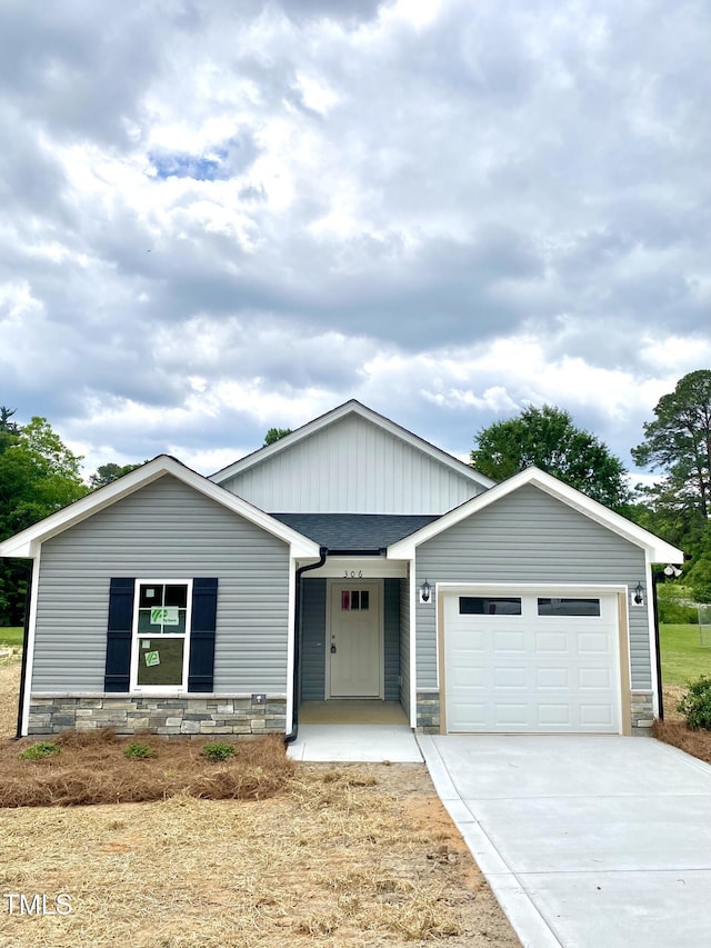 306 E Roseboro St, Roseboro, NC 28382 - ranch-style home featuring a garage, driveway, stone siding, and a shingled roof
