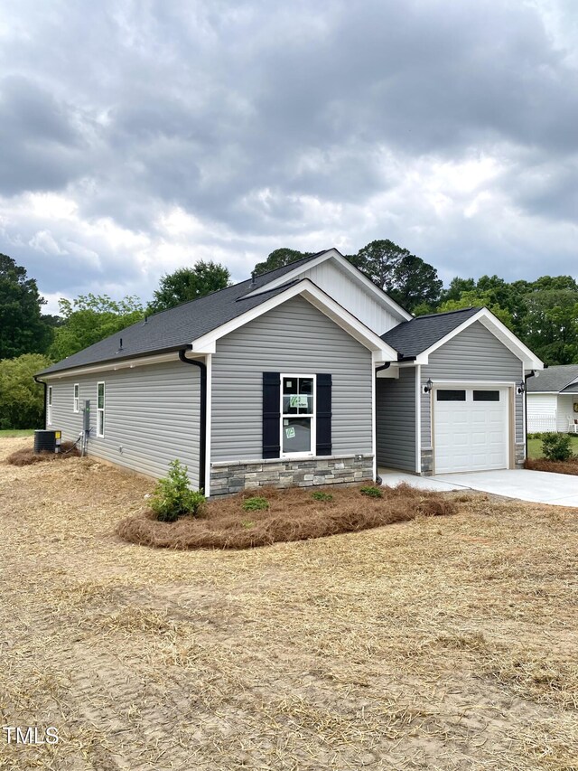 306 E Roseboro St, Roseboro, NC 28382 - ranch-style house with a garage, driveway, a shingled roof, and stone siding